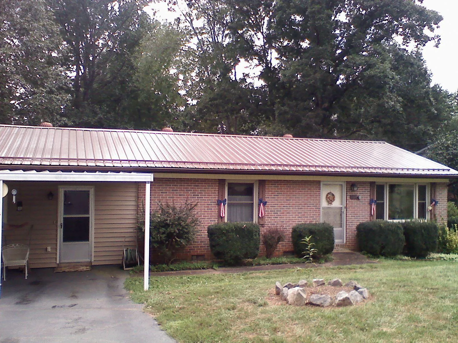 Bronze metal roof and carport on a brick ranch home — Roof Repair work by our crew in Falmouth